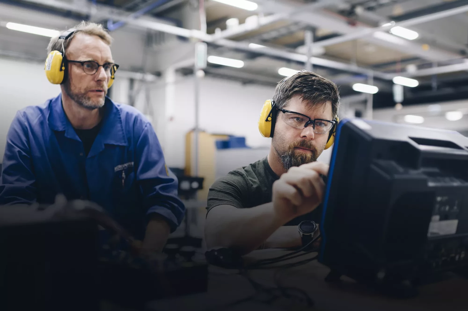 Två operatörer vid monitorer med mjukvarusystem