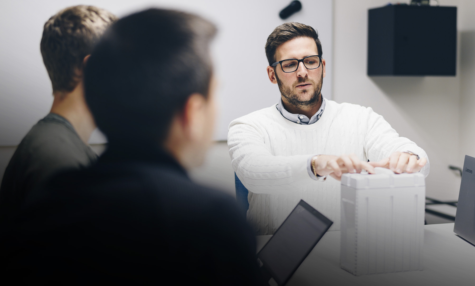 Three male engineers in a meeting about battery charging systems for industrial use