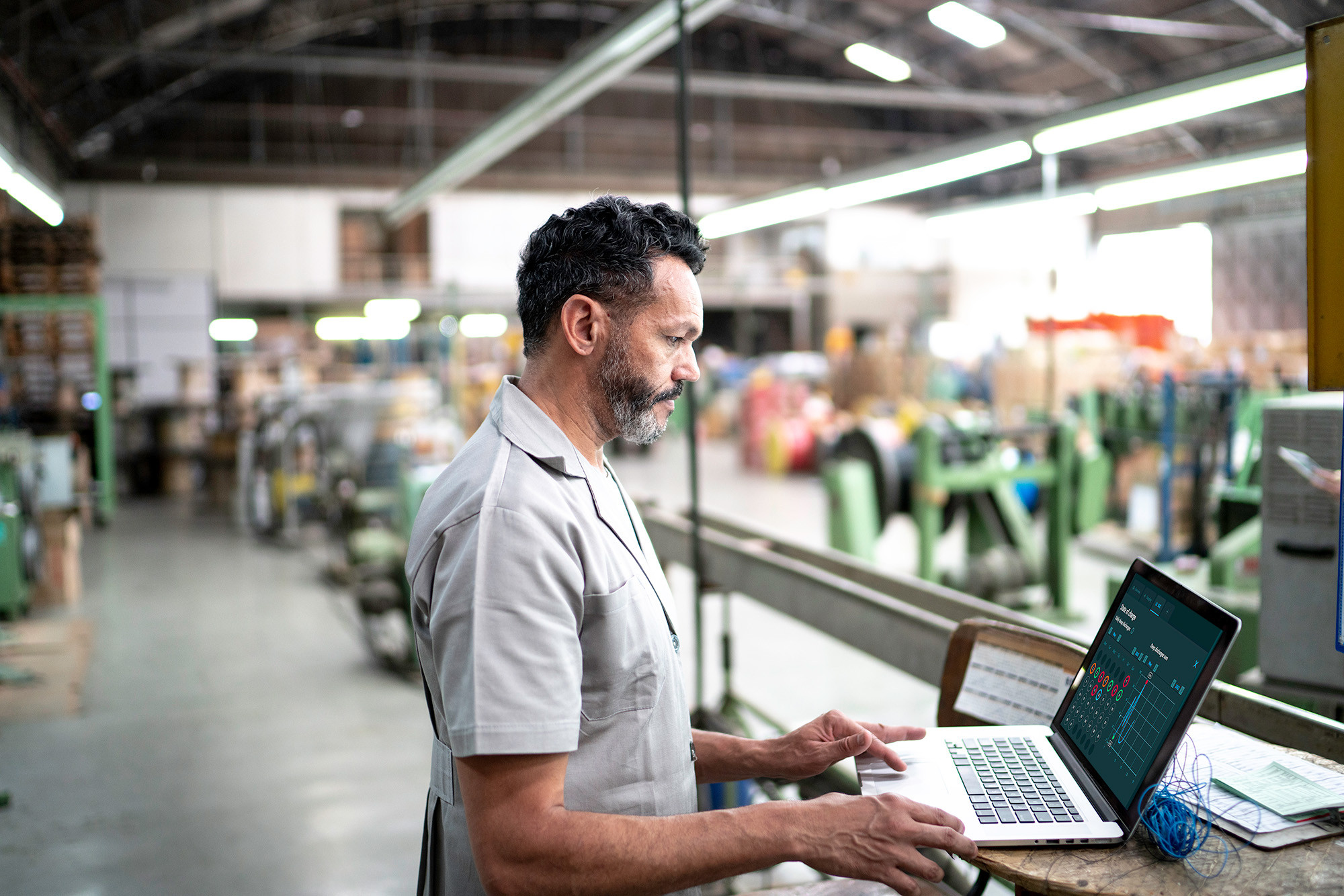 A man at a computer in a factory environment