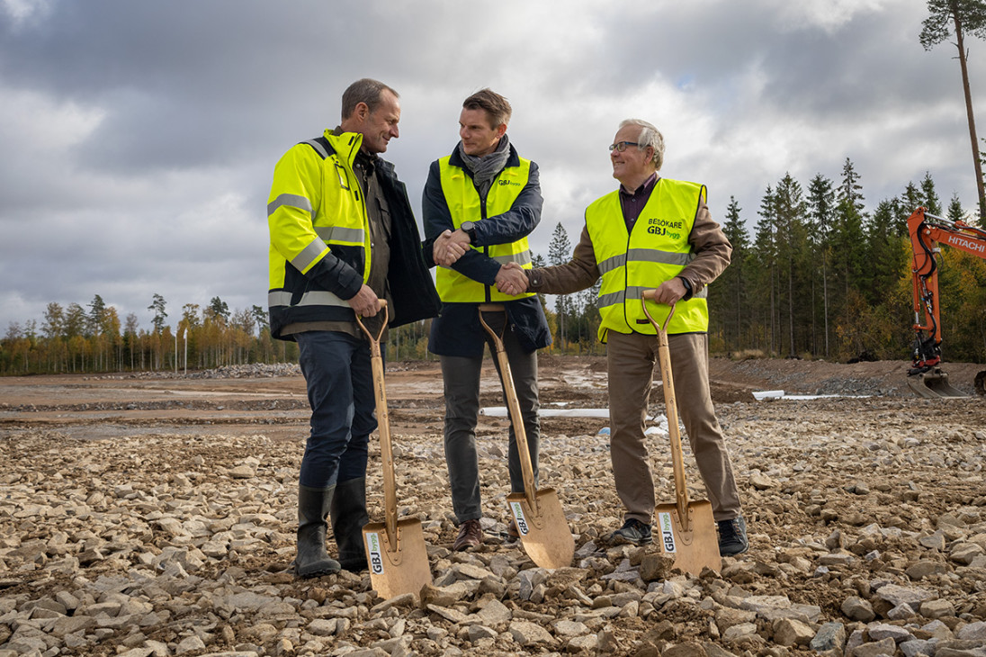 Three men with yellow vests and shovels shake hands