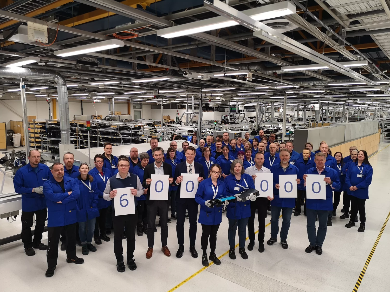 Anställda på Micropower står samlade i fabriken och firar