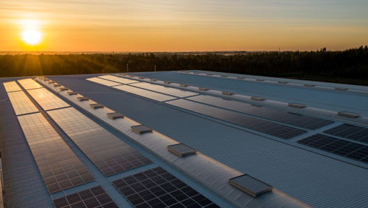 Factory roof with solar panels at sunset